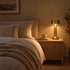 Cordless gold table lamp on an oak bedside table in a calm bedroom