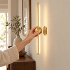 Hand placing the wall light onto its magnetic wall mount, no wiring