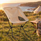 Beige folding camping chair on a coastal headland at golden hour