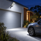 Solar flood light lighting up a driveway at night