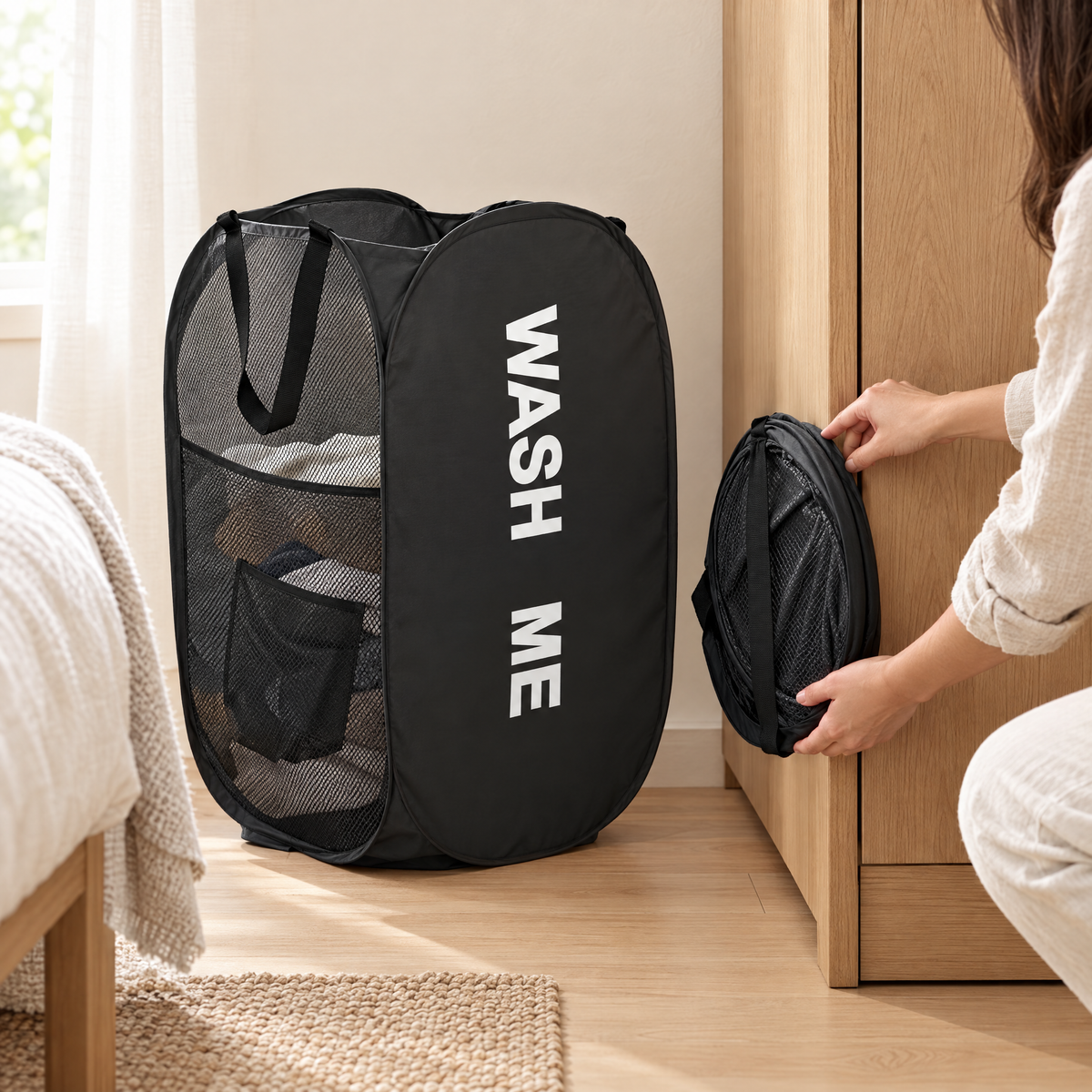 Black laundry hamper open beside one folded flat for storage
