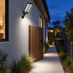 Solar flood light lighting a side path and gate at dusk